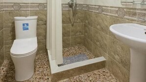 Un baño con ducha, inodoro y lavamanos.