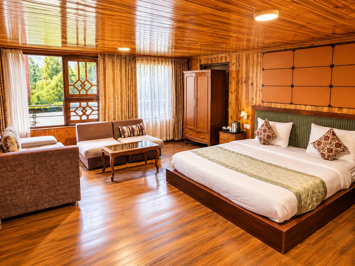 Una habitación de hotel con una cama grande, un sofá, una mesa de centro y un armario.