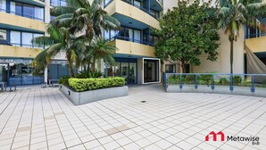 A multi-story building with balconies, a medical practice sign, and a gated entrance. - MetaWise BNB Modern Studio in Central Cronulla 2 (Cronulla)