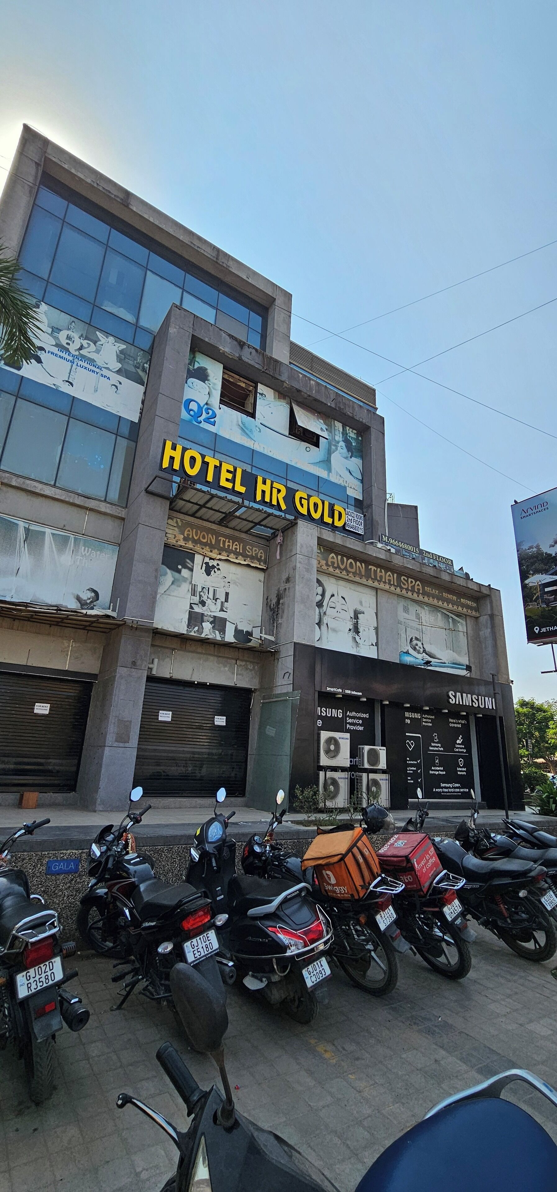 A hotel with a sign reading 'HOTEL HR GOLD' and a Samsung store on the ground floor.