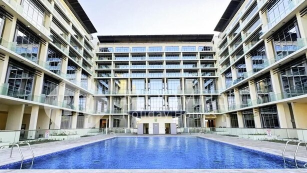 A modern building with a central pool, multiple balconies, and a symmetrical facade. - Bloomfields Delight 1br In Masdar (Abu Dhabi)