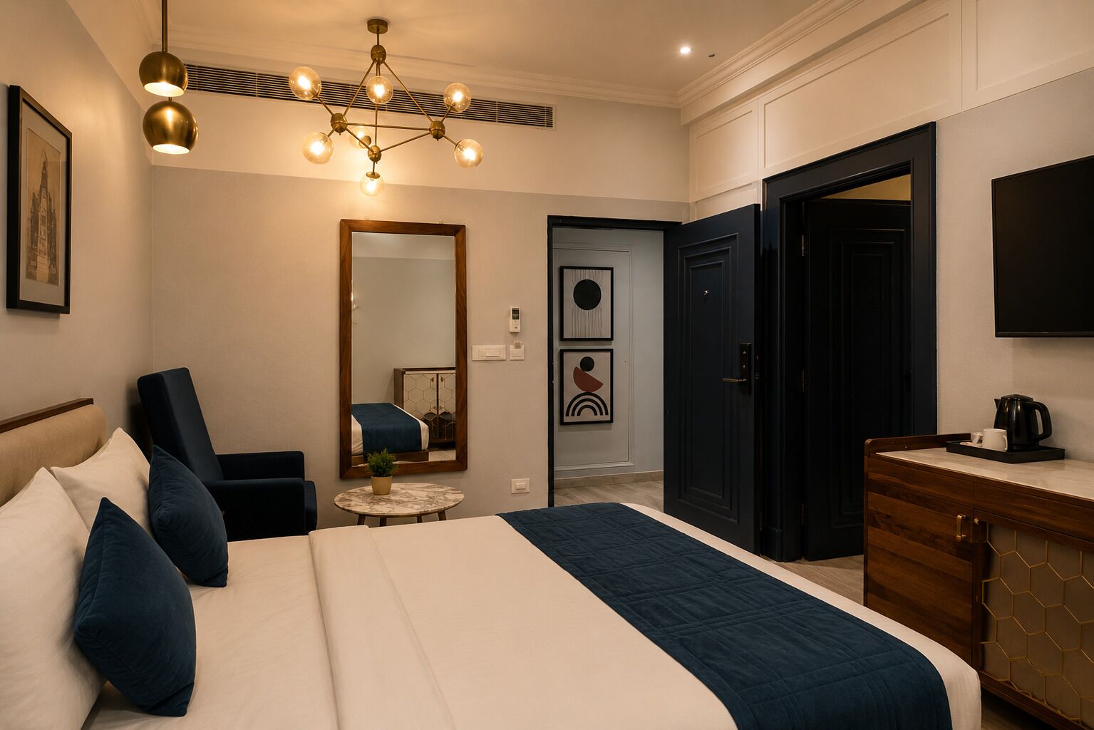 A hotel room with a bed, a chair, a desk, a mirror, a door, and a television.