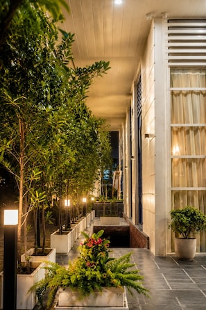 A corridor with potted plants, a bench, and a tiled floor. - Belmonte House, Udaipur (Udaipur)