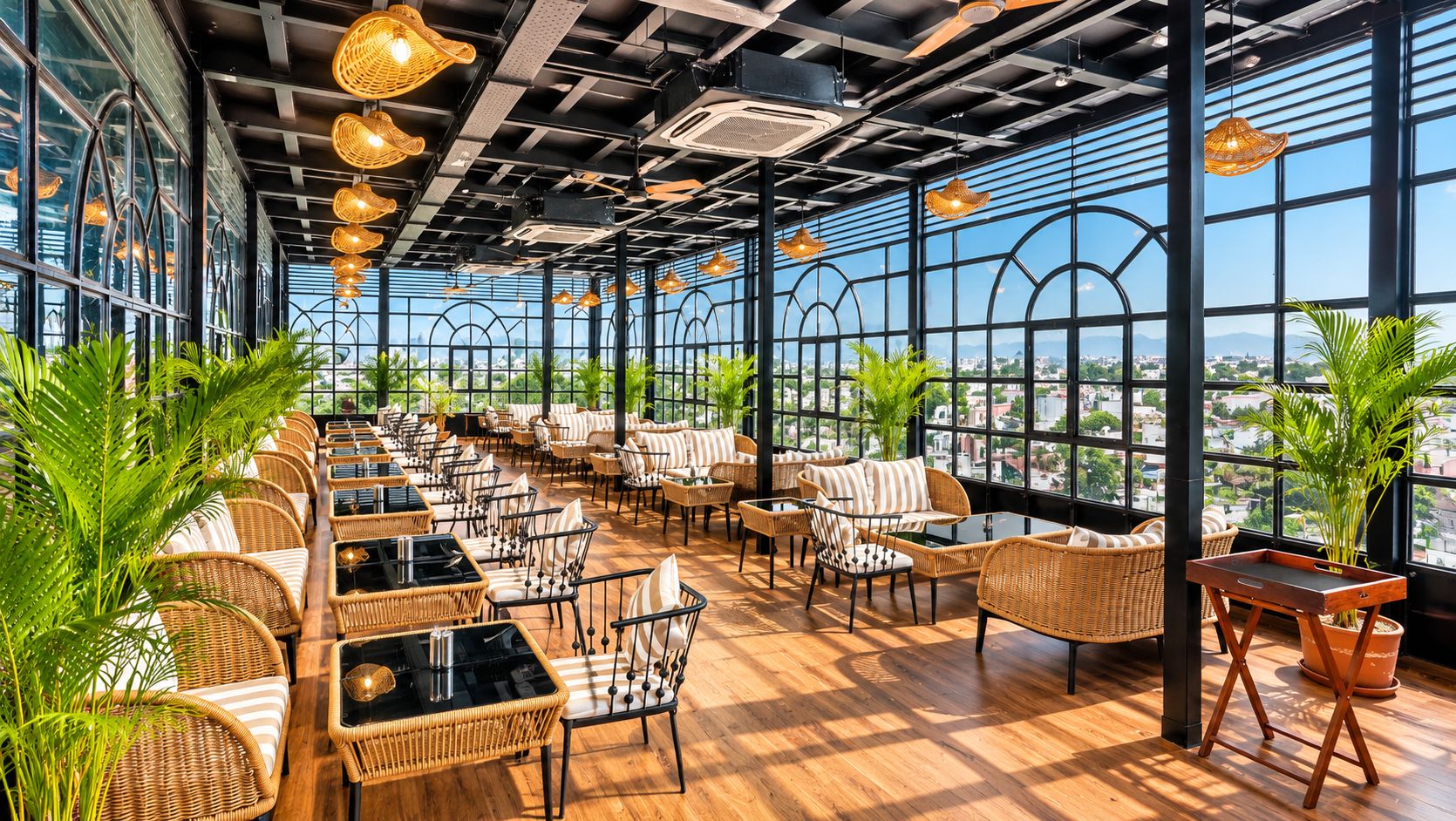 Un espacio interior amplio con mobiliario de mimbre, ventanas grandes y vistas a la ciudad.