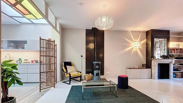 A modern living room with a glass coffee table, a decorative floor lamp, a sofa, and a fireplace. - Anavel Atao (Lille)