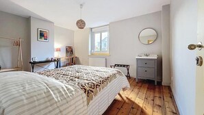A bedroom with a bed, a bedside table, a dresser, a mirror, a window, and a door. - Anavel Atao (Lille)