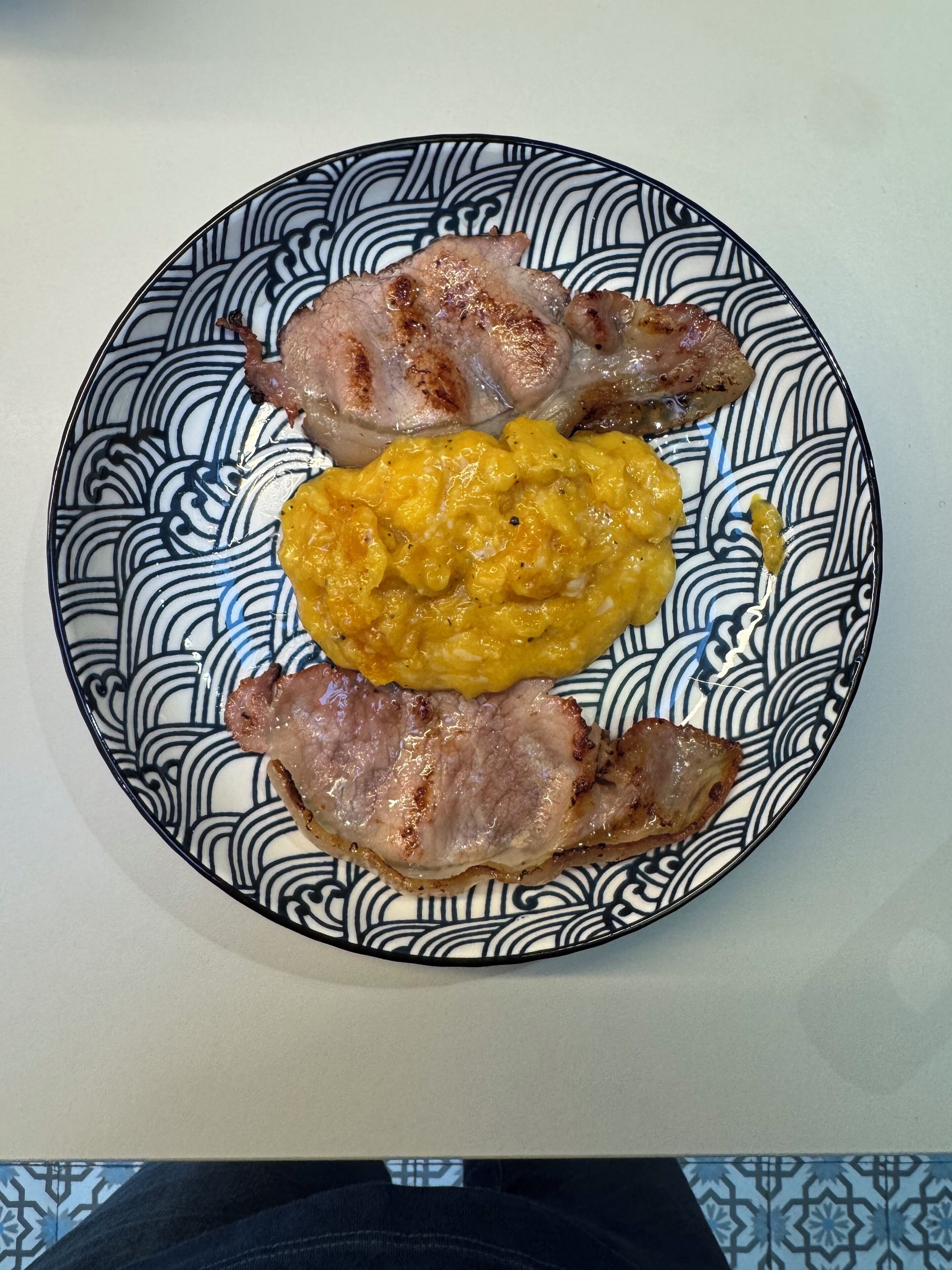 Une assiette avec de la viande grillée et une sauce jaune.