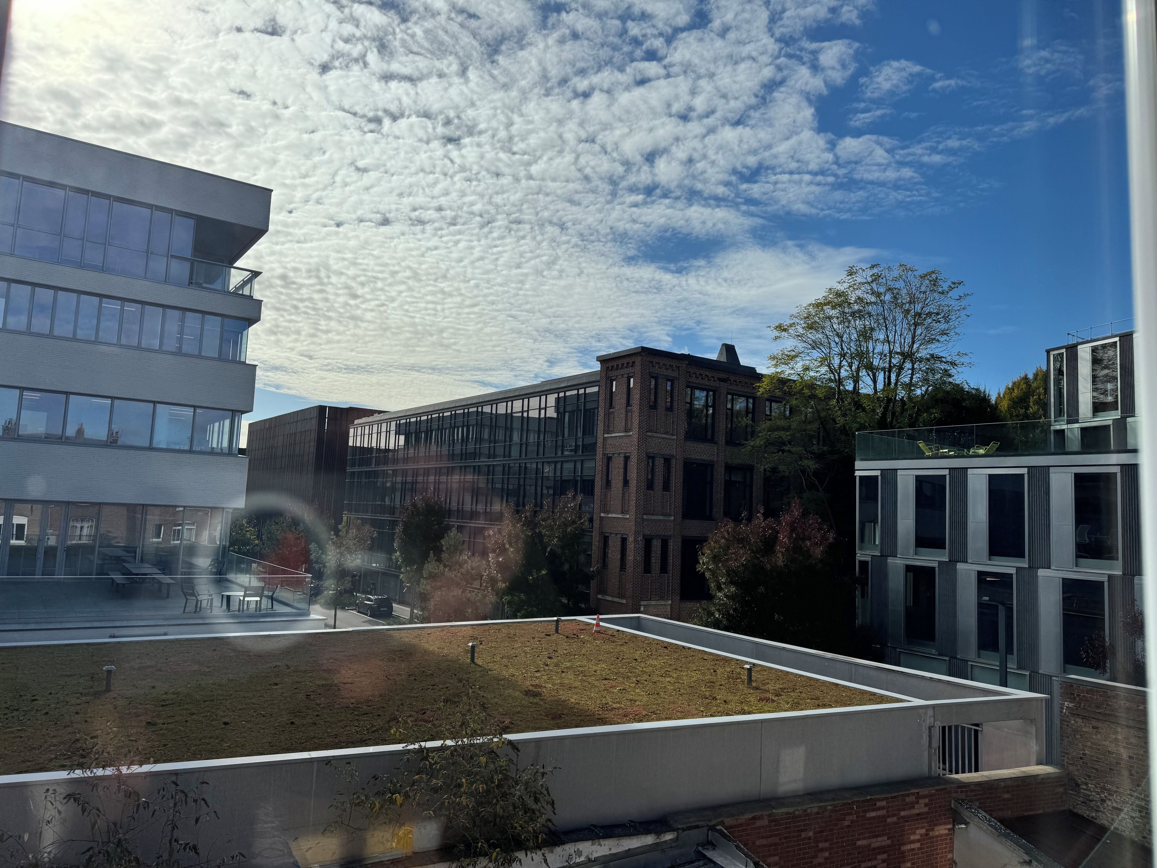 Un edificio moderno con varios pisos, ventanas amplias y techo plano.