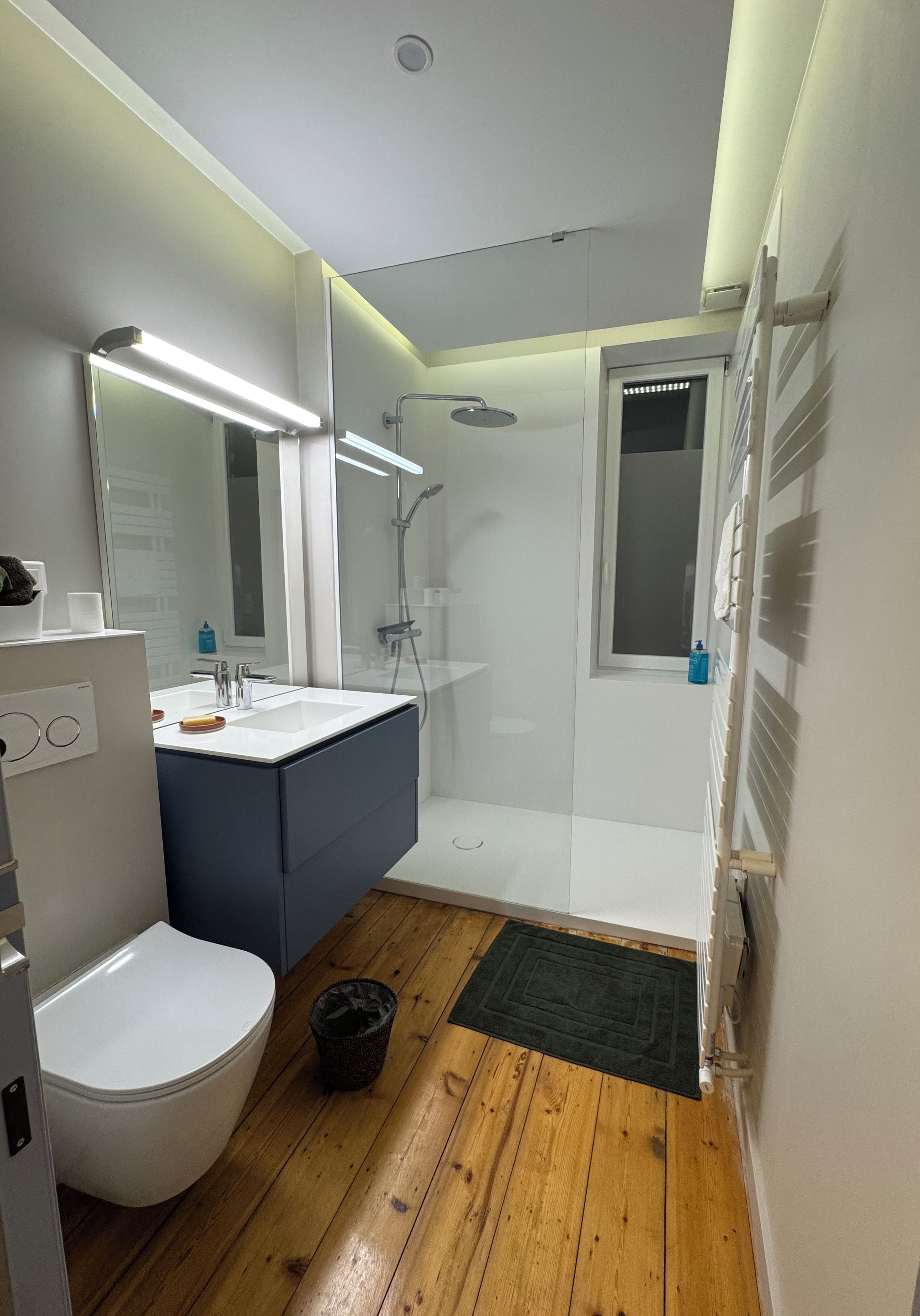 Een moderne badkamer met toilet, wastafel en douche.