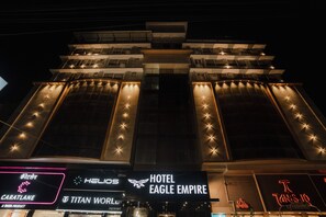 A multi-story hotel with illuminated signage, including 'Hotel Eagle Empire' and 'Titan World.'