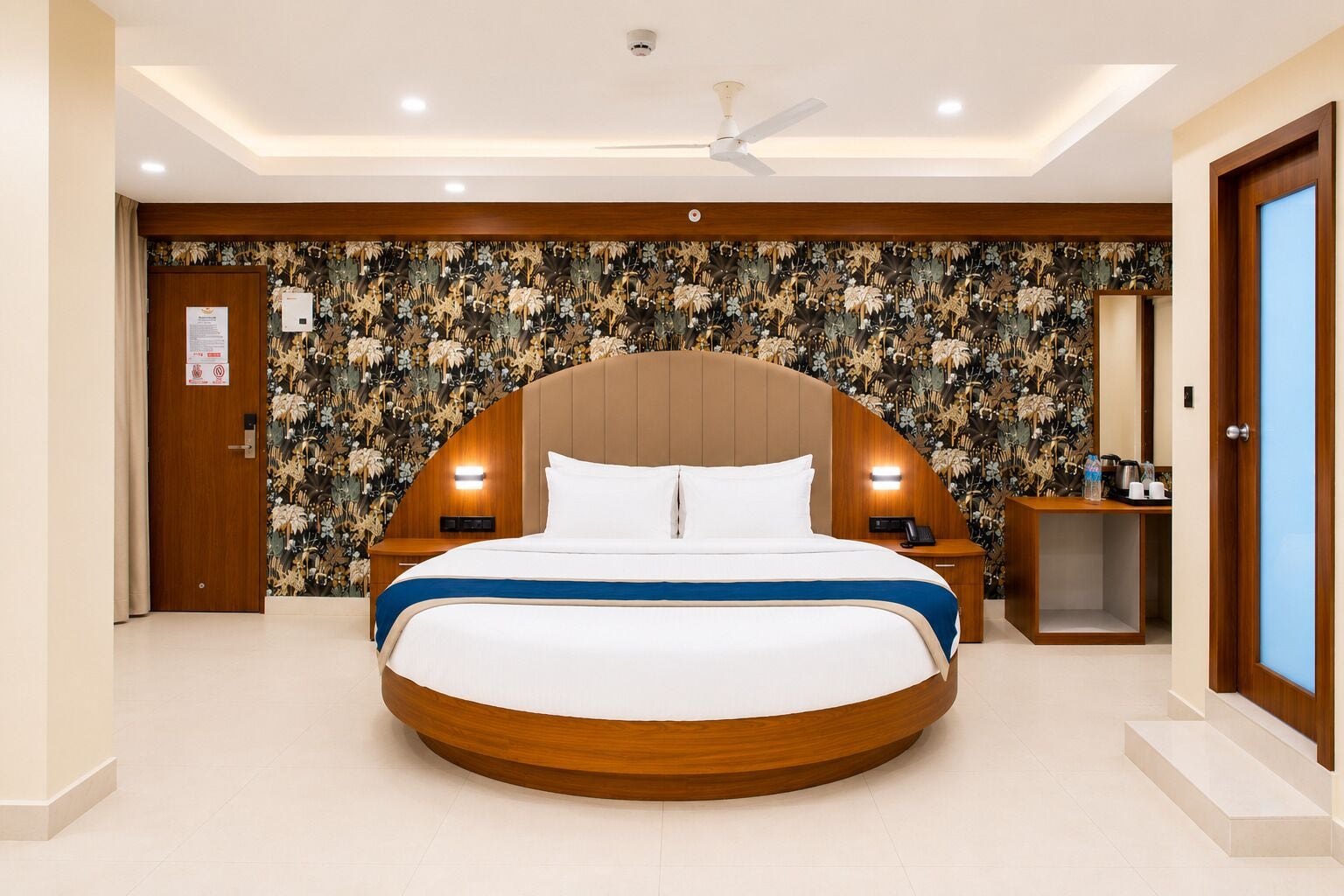 Una habitación de hotel con una cama grande, cabecera de madera, mesita de noche, escritorio y decoración en la pared.