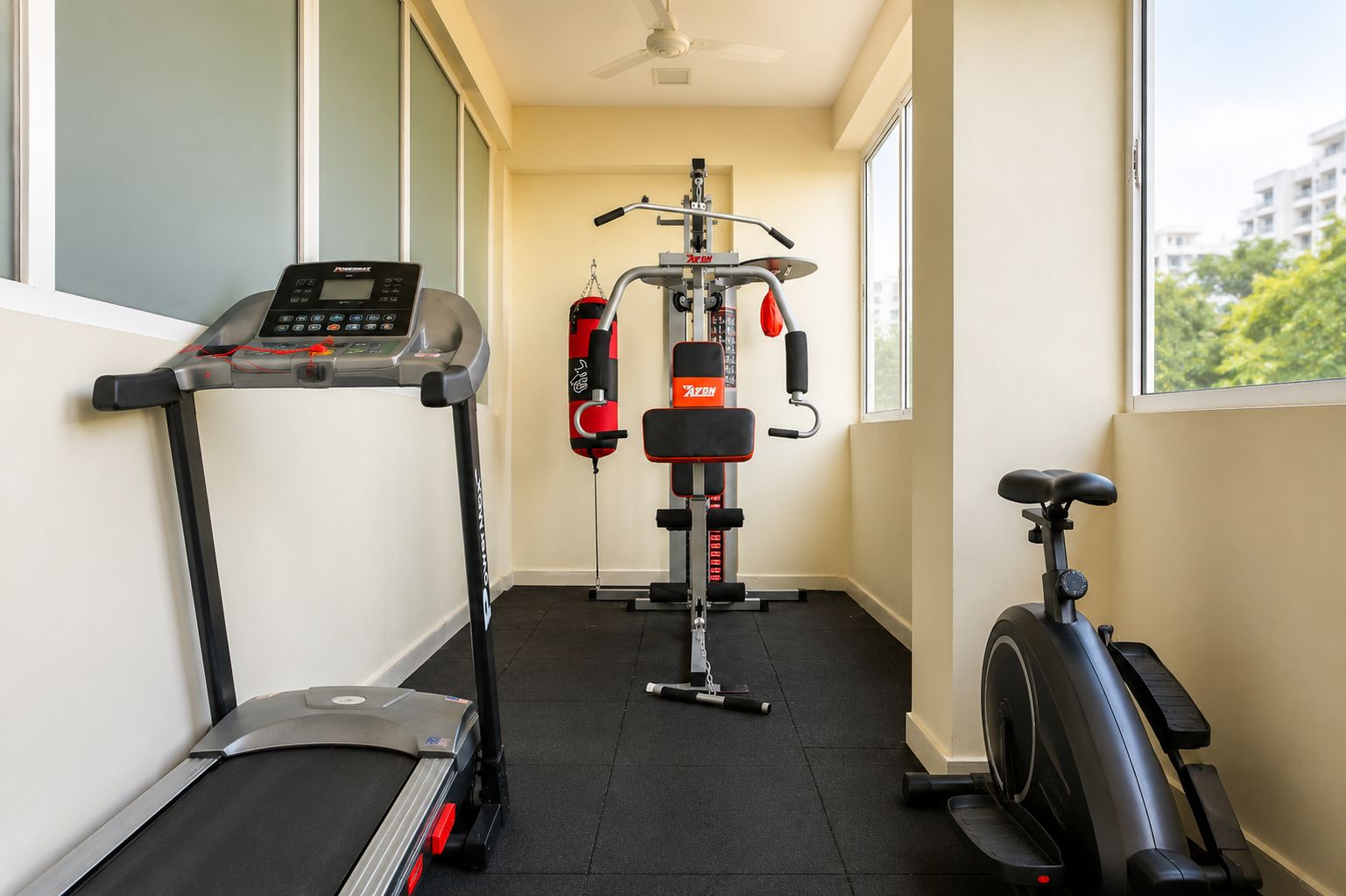 A home gym with a treadmill, a stationary bike, and a weight machine.