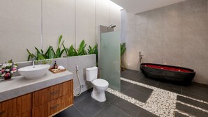 A modern bathroom with a large white sink, a toilet, and a black bathtub. - Beachside Luxury 3BR Tropical B (Denpasar)