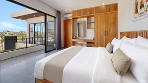 A modern bedroom with a large bed, a wooden wardrobe, a desk, and a balcony with a view. - Beachside Luxury 3BR Tropical B (Denpasar)
