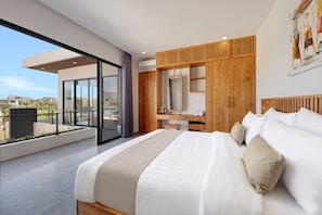 A modern bedroom with a large bed, a wooden wardrobe, a desk, and a balcony with a view. - Beachside Luxury 3BR Tropical B (Denpasar)