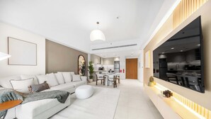 A modern living room with a sofa, coffee table, and dining area. - StayShort - Modern 1BR Retreat in MJL Sleeps 4 (Madinat Jumeirah Living)