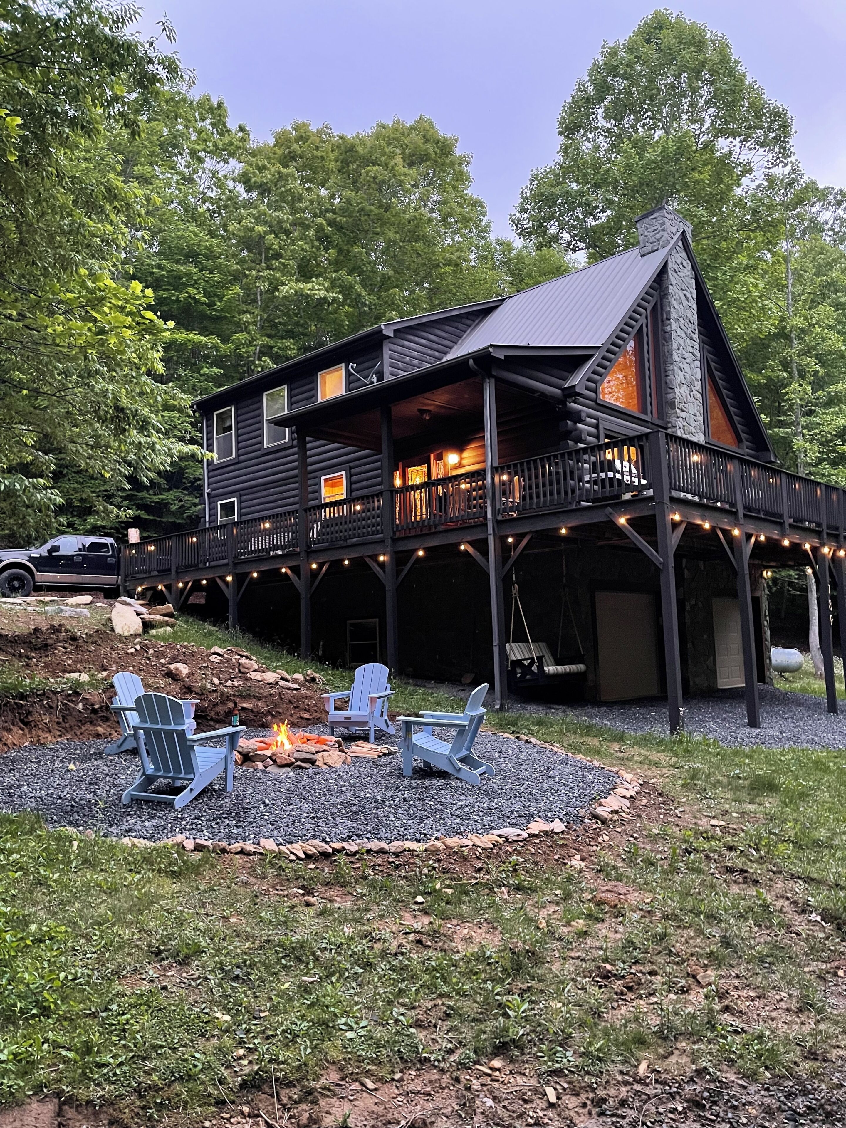A lodge with a porch, outdoor seating, and a fire pit.