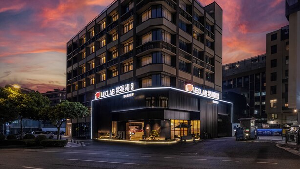 Un hotel de diverses plantes amb disseny modern, amb una entrada destacada que compta amb zona coberta i terrassa.