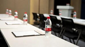 Una sala de conferències amb taules, cadires i ampolles d'aigua.