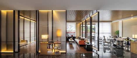 A modern lobby with a marble floor, seating areas, and a view of the outside.