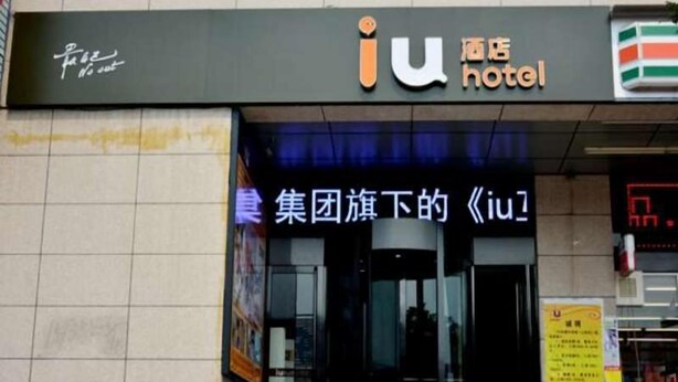 A hotel entrance with a sign for 'iu hotel' and a neon sign for 'iu hotel' in Chinese characters. - IU Hotel (Taiyuan)