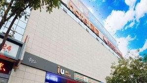 A hotel with a large sign, a 7-Eleven store, and a visible entrance. - IU Hotel (Taiyuan)