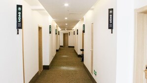 A hotel corridor with doors labeled with room numbers and a carpeted floor. - Greentree Inn (Huai'an)