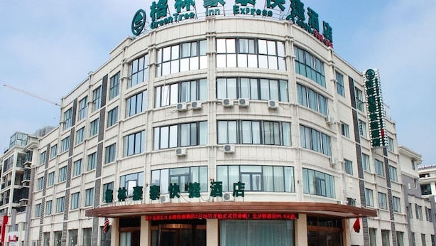 A multi-story hotel with a curved facade, large windows, and a prominent signage indicating it is an Express Inn. - Greentree Inn (Huai'an)