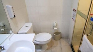 A bathroom with a toilet, a sink, and a shower area. - Hanting Hotel Ji'nan Baotu Spring (Jinan)