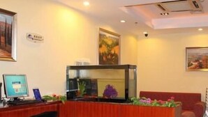 A reception desk with a computer, a fish tank, and a couch. - Hanting Hotel Ji'nan Baotu Spring (Jinan)