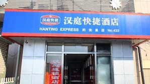 A hotel entrance with a blue and red signboard, a glass door, and a white picket fence in the background. - Hanting Hotel Ji'nan Baotu Spring (Jinan)