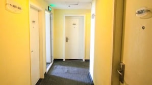 A hotel hallway with doors labeled 8601 and 8605, carpeted floor, and a light fixture on the ceiling. - Hanting Hotel Ji'nan Baotu Spring (Jinan)