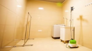 Un baño pequeño con azulejos, que incluye una ducha, un inodoro y un aspirador.