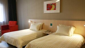 A hotel room with two beds, a red chair, and a framed picture on the wall. - Jinjiang Inn Wuhan Jiangtan Nanjing Road Science Museum (Wuhan)