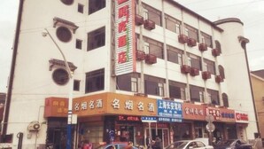 A multi-story building with several commercial establishments on the ground floor, including a hotel and various shops.