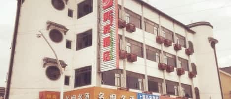 A multi-story building with several commercial establishments on the ground floor, including a hotel and various shops.