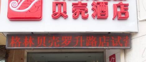 A hotel sign with a logo and Chinese characters.