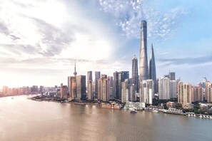 A cityscape with high-rise buildings, a river, and a prominent tower. - JI Hotel Shanghai Baoshan Youyi Road Branch (Shanghai)