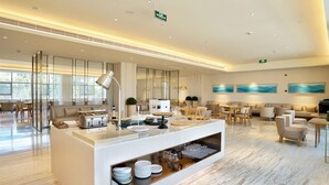 A modern hotel lobby with a reception desk, seating area, and artwork on the walls. - JI Hotel Shanghai Baoshan Youyi Road Branch (Shanghai)
