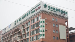 A multi-story building with a prominent sign indicating it is a hotel. - Greentree (Suzhou)