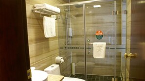A bathroom with a glass shower enclosure, a toilet, and a sink.