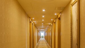A long, narrow hallway with a patterned carpet, doors on both sides, and recessed lighting on the ceiling. - Vienna Classic Hotel Anhui Tongcheng (Anqing)