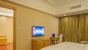 A hotel room with a bed, a desk with a computer, a television on the wall, and a curtain. - Vienna Classic Hotel Anhui Tongcheng (Anqing)