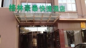 A hotel entrance with a glass canopy and signage in a foreign language. - Greentree Inn Express (Nanjing)
