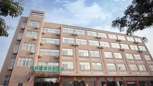A multi-story building with a flat facade, multiple windows, and air conditioning units. - Greentree Inn Express (Nanjing)