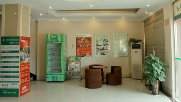 A lobby with a vending machine, informational posters, a plant, and a ceiling light fixture. - Greentree Inn Anhui Anqing Yingjiang Temple Xiaosu Road Shell Hotel (Anqing)