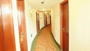 A hotel hallway with wooden doors, a carpeted floor, and a ceiling light. - Greentree Inn Anhui Anqing Yingjiang Temple Xiaosu Road Shell Hotel (Anqing)