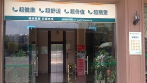 A hotel entrance with a glass door, a sign with Chinese characters, and a potted plant on the right. - Greentree Inn Anhui Anqing Yingjiang Temple Xiaosu Road Shell Hotel (Anqing)