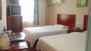 A hotel room with two beds, a desk with a computer, a television, and an air conditioning unit. - Greentree Inn Anhui Anqing Yingjiang Temple Xiaosu Road Shell Hotel (Anqing)