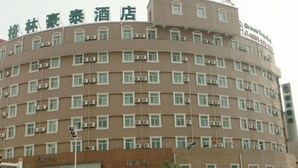 A multi-story hotel with a curved facade, multiple air conditioning units, and a sign indicating it is a hotel. - Greentree Inn Anhui Anqing Yingjiang Temple Xiaosu Road Shell Hotel (Anqing)